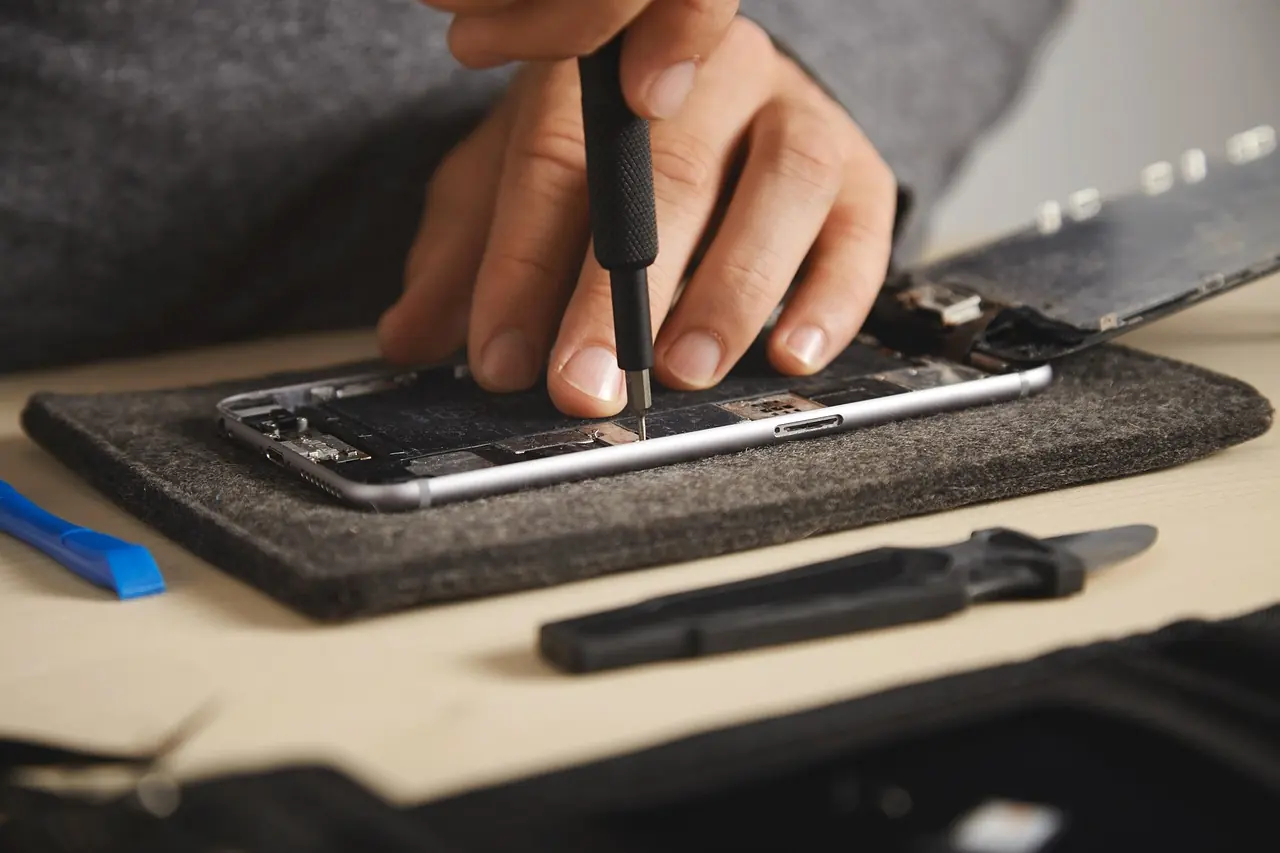 Technician servicing a smartphone at a professional repair centre