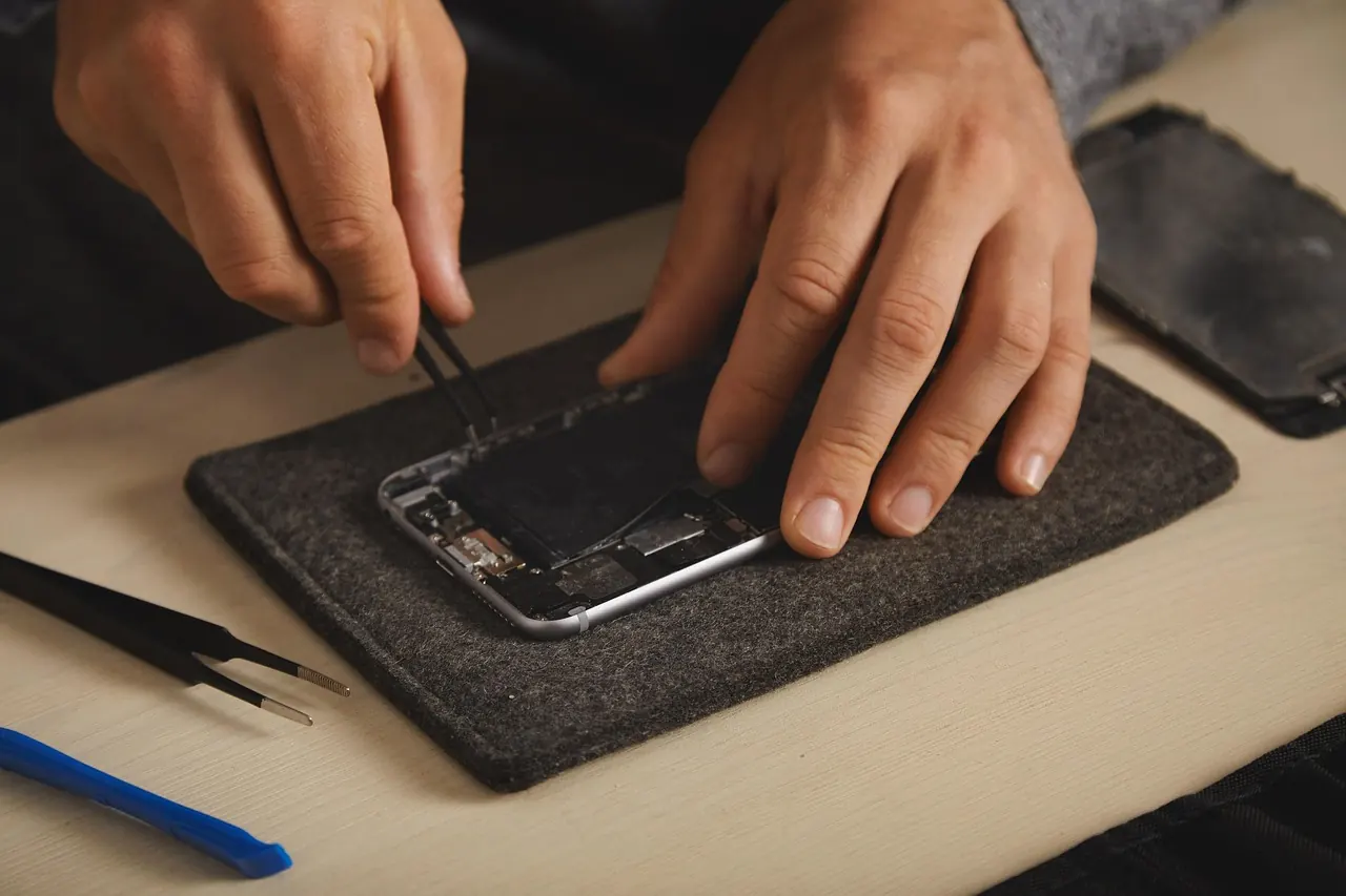 Hands performing a precision smartphone repair