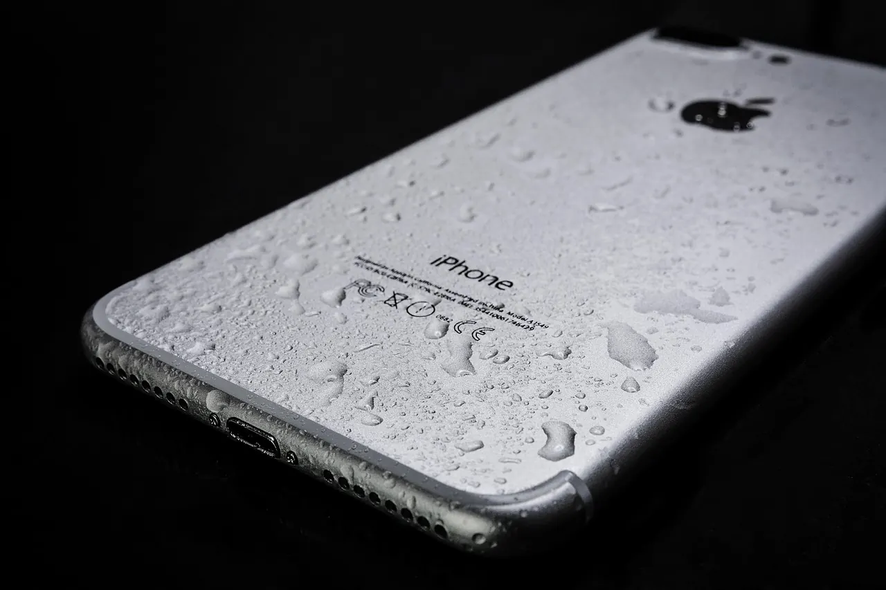 Wet smartphone with water droplets — water damage indication